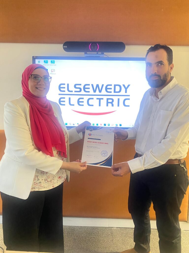 Photo of Dr. Heba abdalla delivering a certificate to a graduate from AL Sweedy COrp Quality Training program